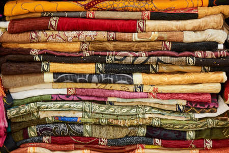 Pile of colorful folded textile. Heap of cloth fabricの写真素材