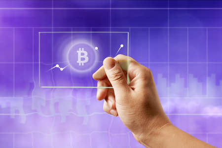 Icon bitcoin on a glass screen with a graph of crypto currency on an ultraviolet backgroundの写真素材
