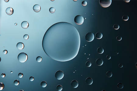 blue big and and small water drops on the glass
