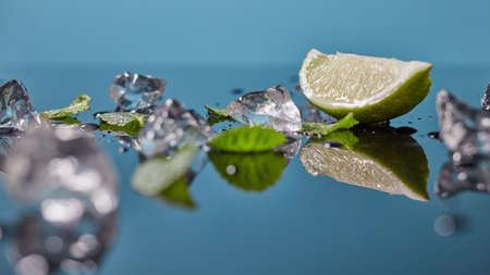 Lime fruit with ice isolated on blue backgroundの写真素材