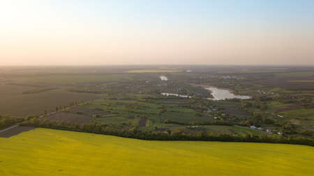 Panoramic view of the field and a small village in the distance against the blue sky, Ukraine