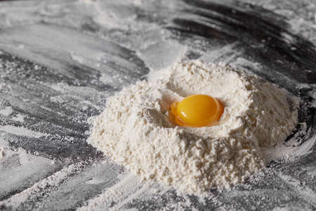 Pile of flour and egg on the kitchen table.の写真素材