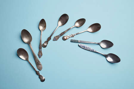 Metal tea spoon isolated on blue with copy space