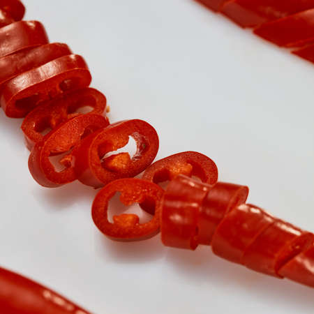 macro photo of chopped red chili pepper on white backgroundの写真素材