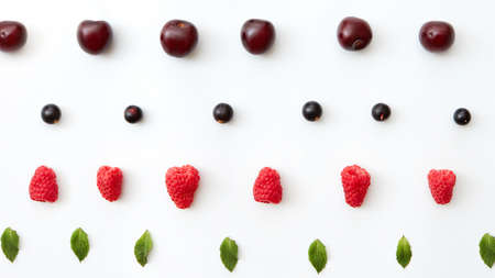 Summer cherries, raspberry, blackbarry, mint leaf pattern isolated on a white background. Flat layの写真素材