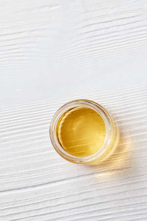 Organic natural honey in a glass jar on a white wooden background. Flat lay.