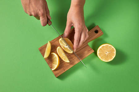Preparation of a natural diet drink with the hands of women on a green background. Concept of healthy diet food.の写真素材