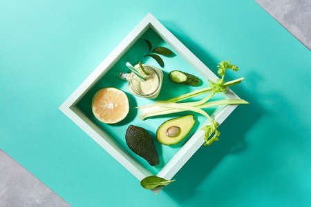 Natural ingredients for healthy smoothie from avocado with cucumber, celery, shpinach, lemon in jar...