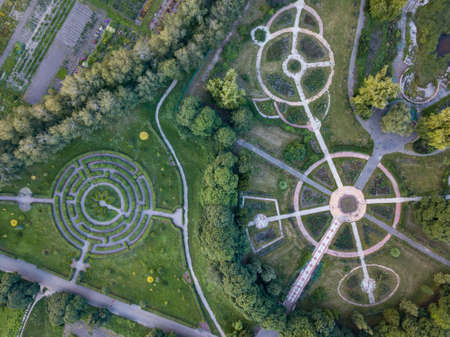 Birds eye view from the drone to a Garden labyrinth and park alleys of the round form in the park.の写真素材