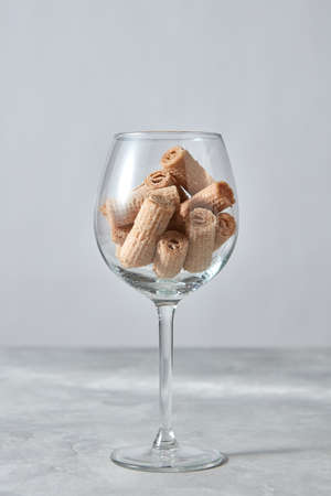Crispy waffle creamy rolls in a glass cup, dessert for wine on a gray background.の写真素材