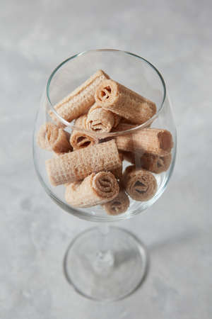 The glass cup with waffle creamy rolls on a gray concrete background.の写真素材