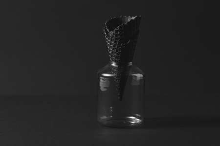 Sweet waffle black cone in a glass on a black paper background.の写真素材