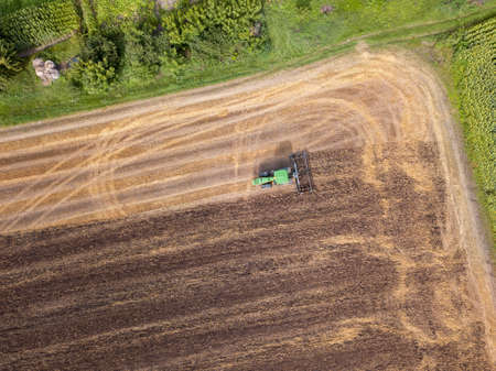 Plowing the ground after harvesting on the field in the autumn time. Top view.
