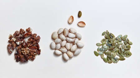 Mix of assorted natural nuts - pistachios, walnuts, pumpkin seed . Organic natural pattern on a white background.の写真素材
