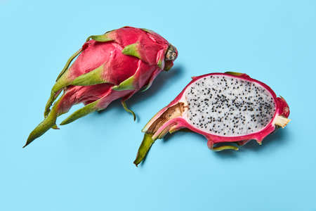 A dragon fruit, or pitahaya represented on a blue background with a copy space. Ripe tropical fruit
