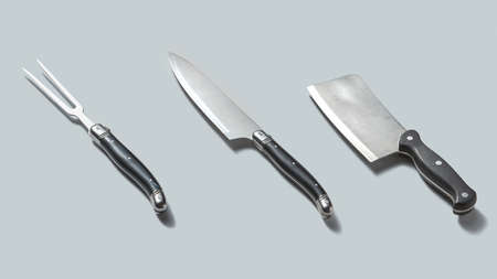 Steel kitchenware for cutting meat isolated on a gray background with shadows, place for text.
