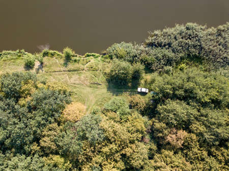 Aerial view from drone recreation place on a bank of river. Top view green trees, meadow and white car. Top view.の写真素材