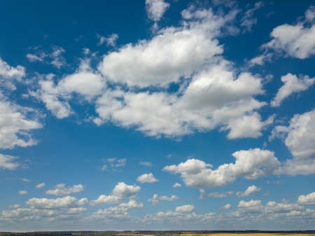 Cloudy aerial landscape with white clouds on a blue sky background. Aerial view from drone.の写真素材