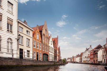 view canal and colorful traditional houses against cloudy blue skyの写真素材