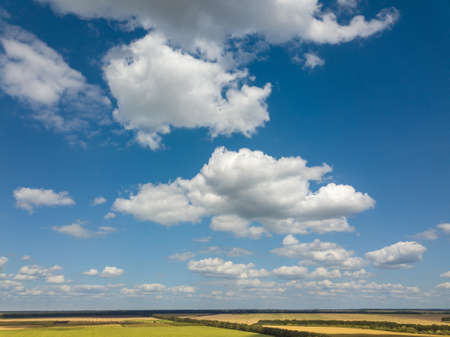 Panoramic landscape with beautiful white clouds and fields on a background of blue sky in a sunny day. Aerial view frome drone,の写真素材