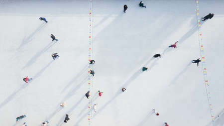 Aerial view of a drone on an open ice rink with people on a winter sunny day.の写真素材