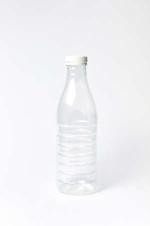 Transparent empty plastic bottle for water or other liquid on a light background, mock up. Place for...
