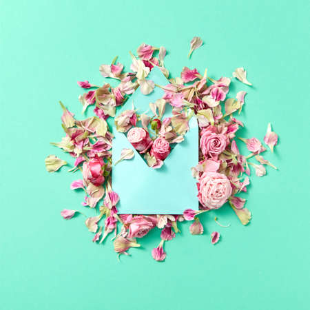 Card for congratulation with envelope and fresh flowers on a light turquoise background.の写真素材