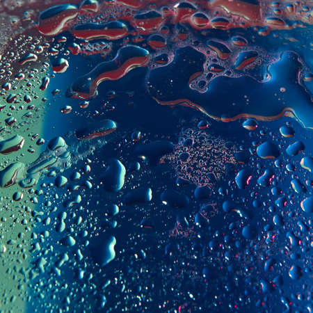 Close up water drops in ultravioler lighting.の写真素材