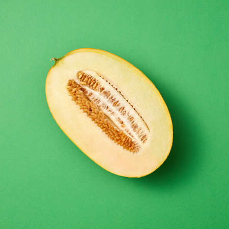 Freshly picked ripe fresh melon fruit cut on a sea green background with copy space.の写真素材