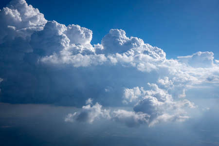 Sun beams are lighting huge white cumulus clouds.の写真素材