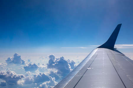 Plane wing on a blue sky cloudy backgroundの写真素材