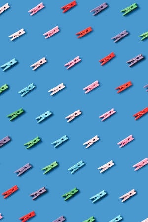 Diagonal pattern from laundry pattern from multicolored clothespegs on a blue background.の写真素材