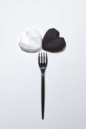 Plaster fork with two gypsum hearts white and black.の写真素材