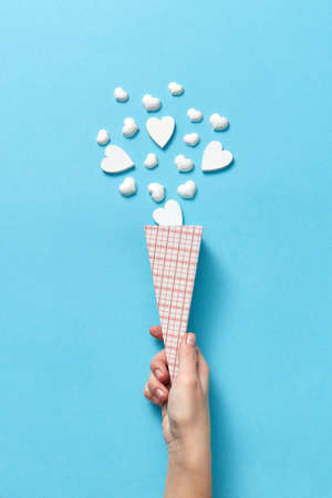 Paper cone with small hearts in womans hand.の写真素材