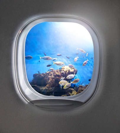 View of cloudy blue clear sky through airplane porthole.の写真素材
