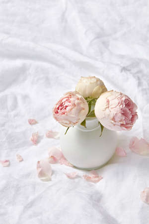 Ceramic vase with roses on a sheet.の写真素材