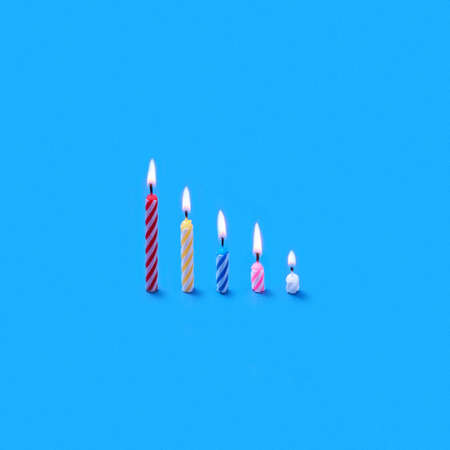Holiday burning multicolored candles of different height.