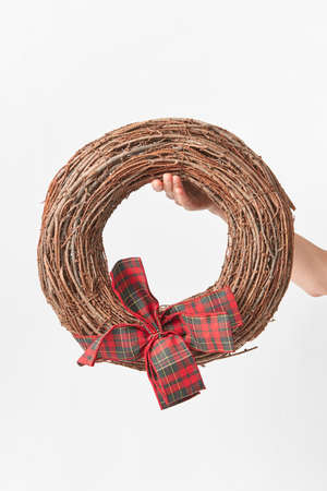 Round wreath from dry twigs with bow in a woman hand.の写真素材