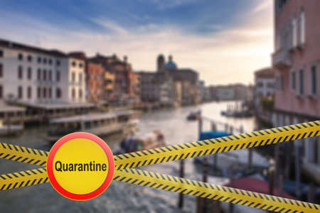 Warning sign of quarantine on crossing police lines on a blurred background of Grand Canal in Venice, Italy.の写真素材