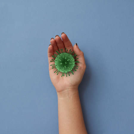 Female hand with model of Coronavirus bacteria.の写真素材