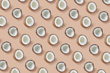 Creative fruits pattern from natural organic tropical coconut's halves on a beige background. Flat lay. Vegan concept.の写真素材