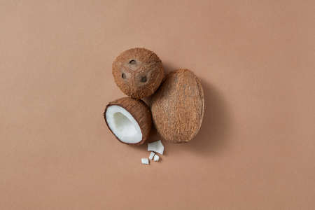 Set from ripe natural organic exotic coconut fruit two whole and one half on a brown background with soft shadows and copy space. Vegan concept. Top view.の写真素材
