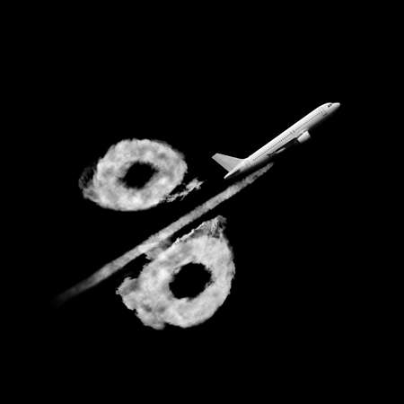Flying plane with air trail in the shape of percentage sign made from clouds on a black background, copy space. Travel discount concept.の写真素材