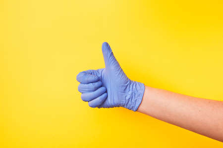 Sign OK made of womans hand in rubber protective glove.の写真素材
