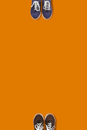 Top view of people feet on the orange background as a social distancing.の写真素材
