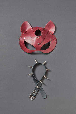 Leather collar with sharp spines and cat BDSM mask on a black background.の写真素材