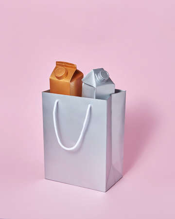 Mock-up silver paper bag with two milk packages on a pink background.