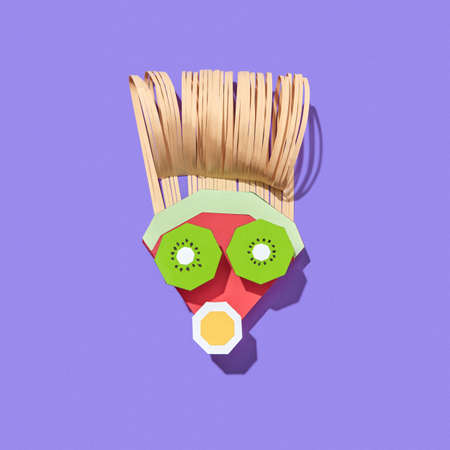 Handmade from colorful paper man's face made from papercraft fruits on a purple background with shadows, copy space. Vegan healthy food.の写真素材