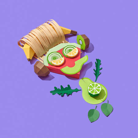 Funny little man handmade from colorful papercraft fruits and vegetables listening to music on a purple background with shadows, copy space. Vegan healthy food.の写真素材