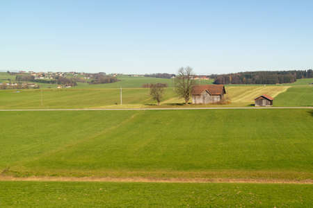 Beautiful countriside with green fields and areas and trees on a background of blue clear sky in autumn time, Austria.の写真素材